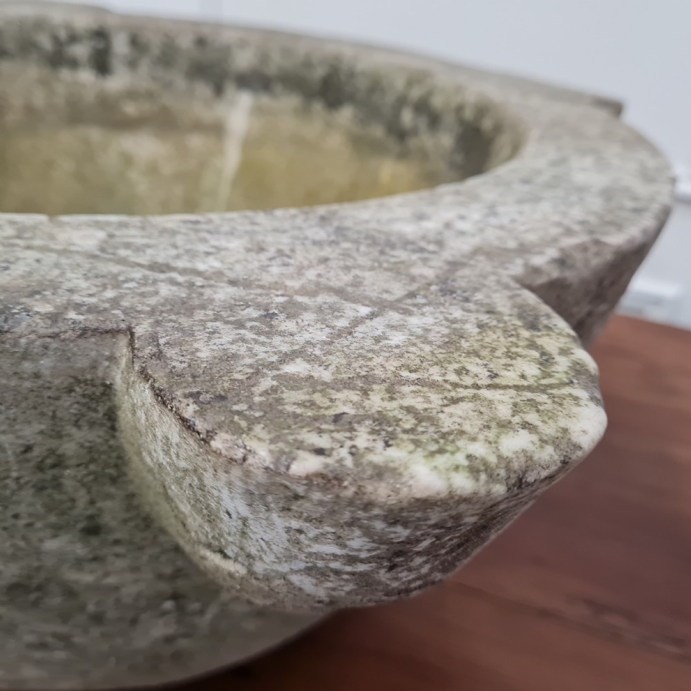 An 18th-century carved white marble mortar featuring four lug handles and a worn interior basin. View VII