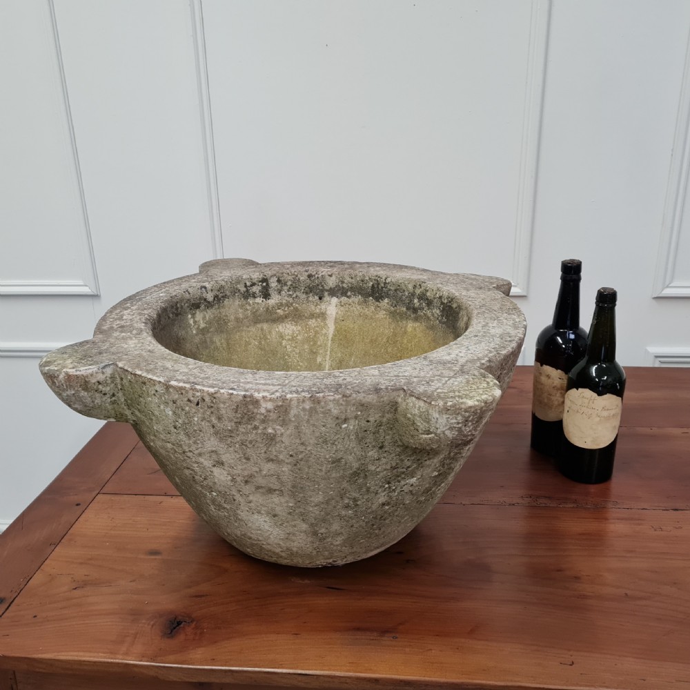 An 18th-century carved white marble mortar featuring four lug handles and a worn interior basin. View VIII