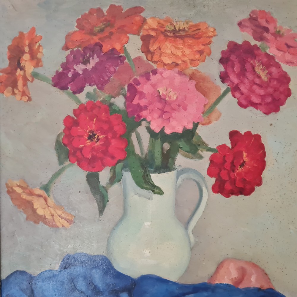 A mid-century still life oil painting depicting a colourful arrangement of flowers in a white pitcher over draped fabric, set within a carved gold frame. View II