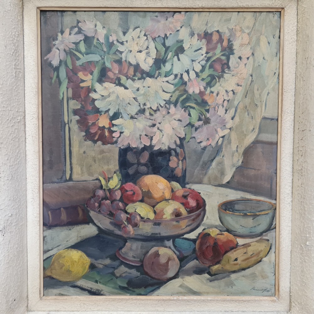 A pair of framed 1930s oil paintings depicting floral arrangements and fruit still life compositions in cream painted wooden frames. View III