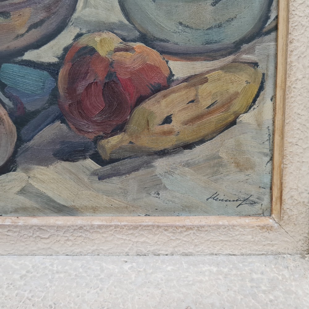 A pair of framed 1930s oil paintings depicting floral arrangements and fruit still life compositions in cream painted wooden frames. View IV