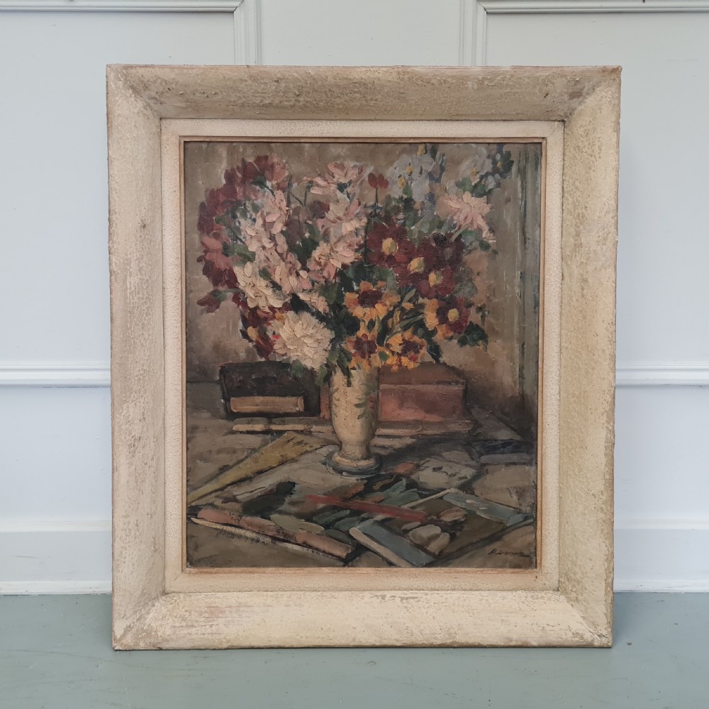 A pair of framed 1930s oil paintings depicting floral arrangements and fruit still life compositions in cream painted wooden frames. View IX