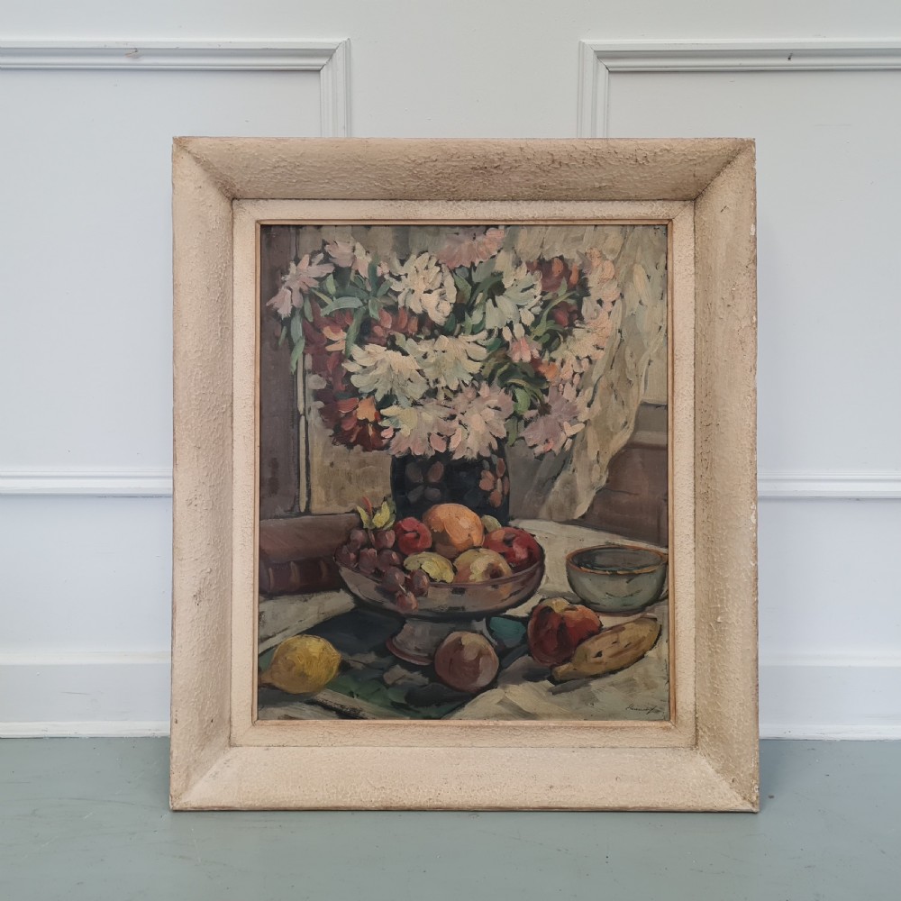 A pair of framed 1930s oil paintings depicting floral arrangements and fruit still life compositions in cream painted wooden frames. View X