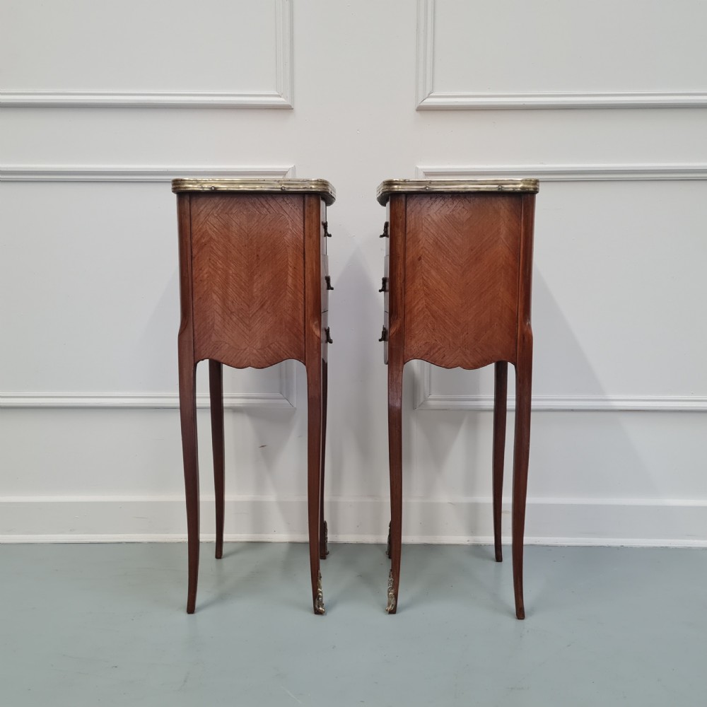 A pair of tall French kingwood bedside cabinets featuring three drawers, brass handles, cabriole legs, and top brass gallery rims. View IV