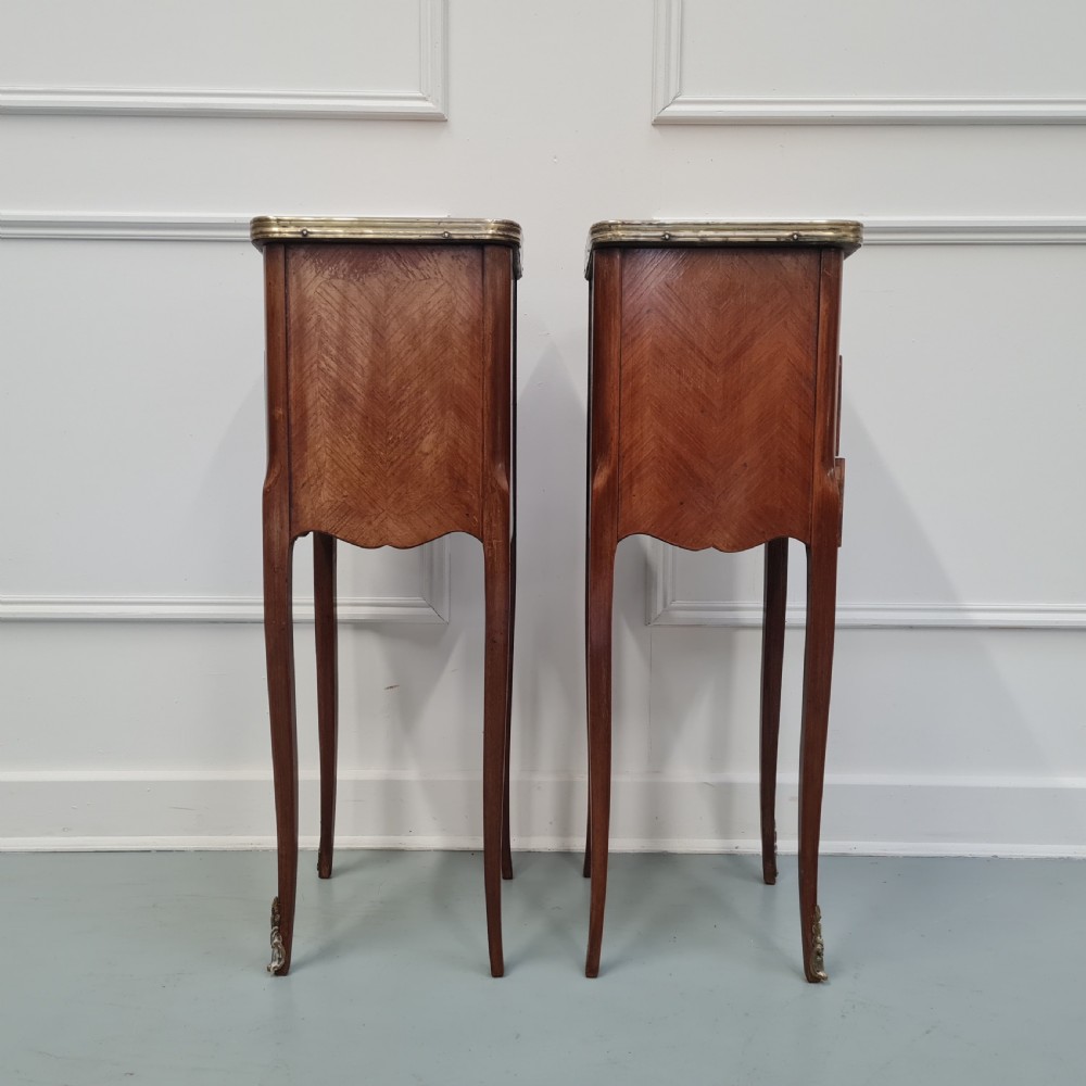 A pair of tall French kingwood bedside cabinets featuring three drawers, brass handles, cabriole legs, and top brass gallery rims. View VII