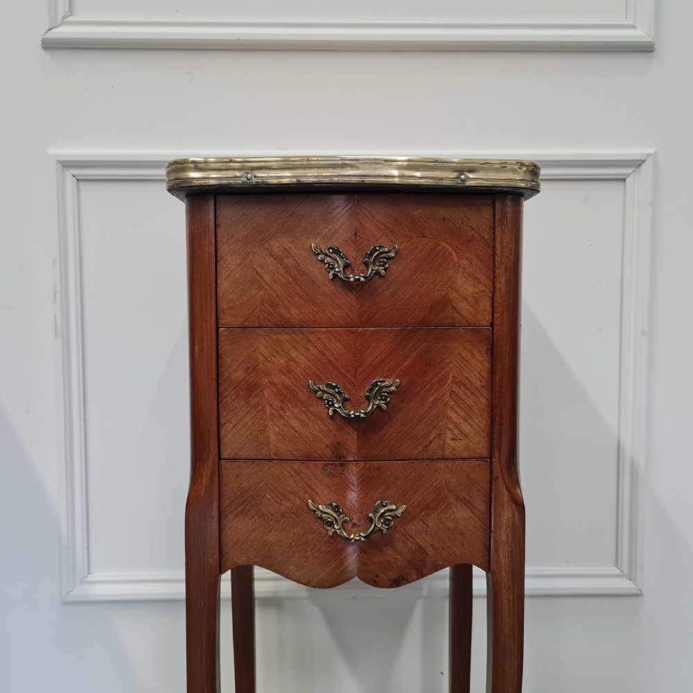 A pair of tall French kingwood bedside cabinets featuring three drawers, brass handles, cabriole legs, and top brass gallery rims. View VIII