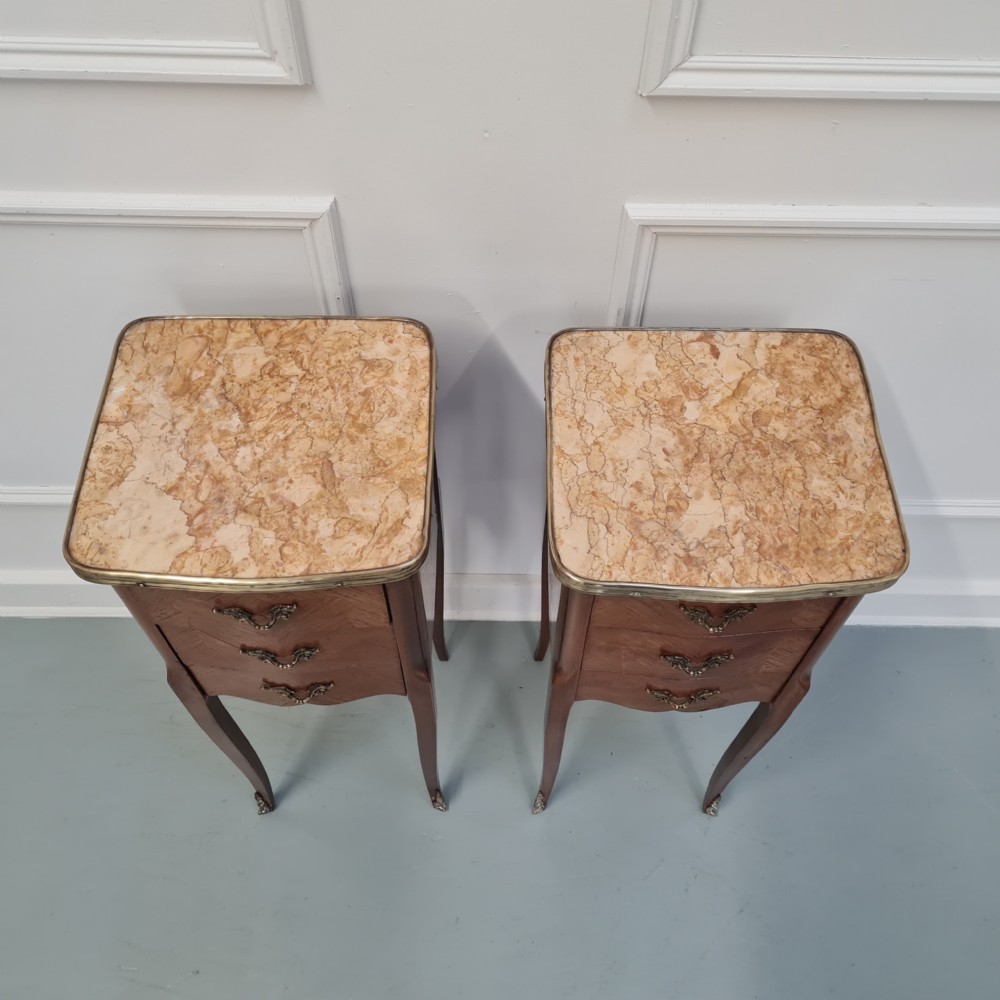 A pair of tall French kingwood bedside cabinets featuring three drawers, brass handles, cabriole legs, and top brass gallery rims. View IX