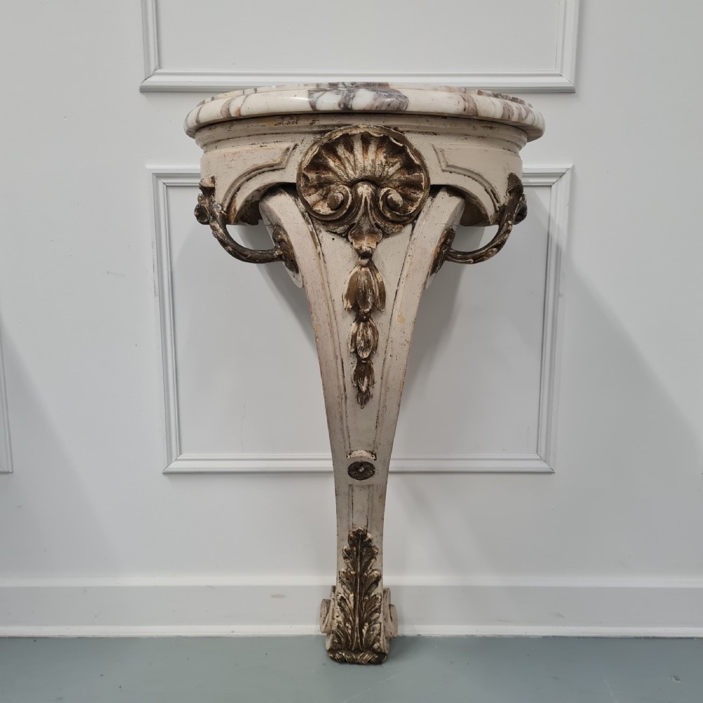 A pair of French nineteenth-century wall-mounted console tables with shaped marble tops and carved gilded single support legs. View II