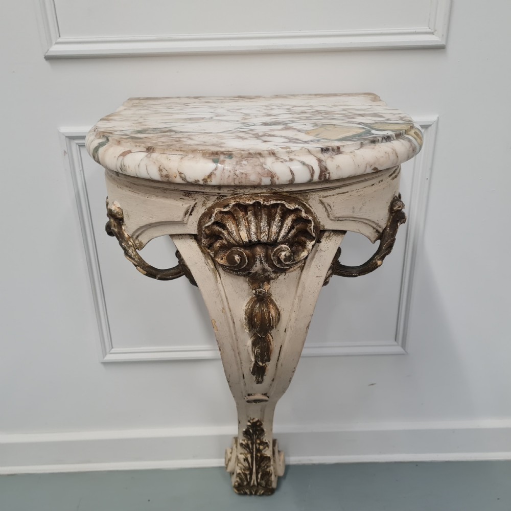 A pair of French nineteenth-century wall-mounted console tables with shaped marble tops and carved gilded single support legs. View IX