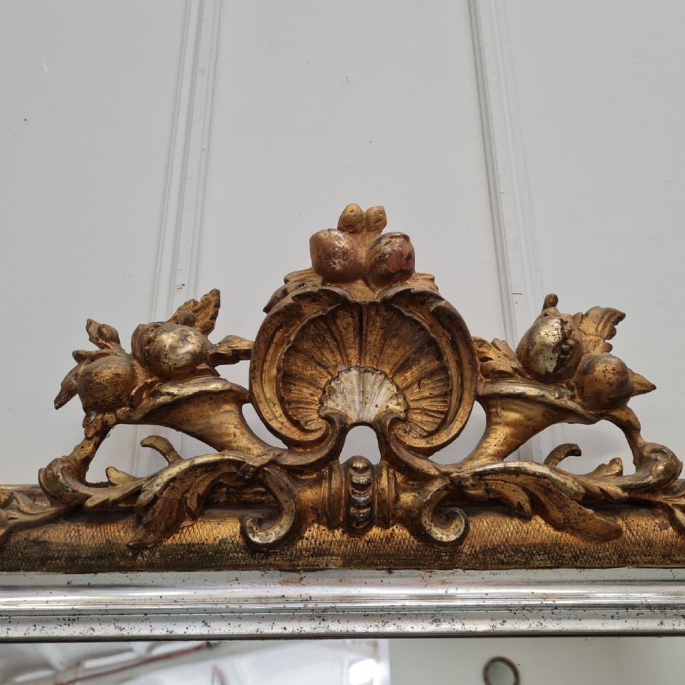 A large 19th-century rectangular French mirror featuring a silver gilded frame crowned with a carved gold Rococo shell cresting. View III