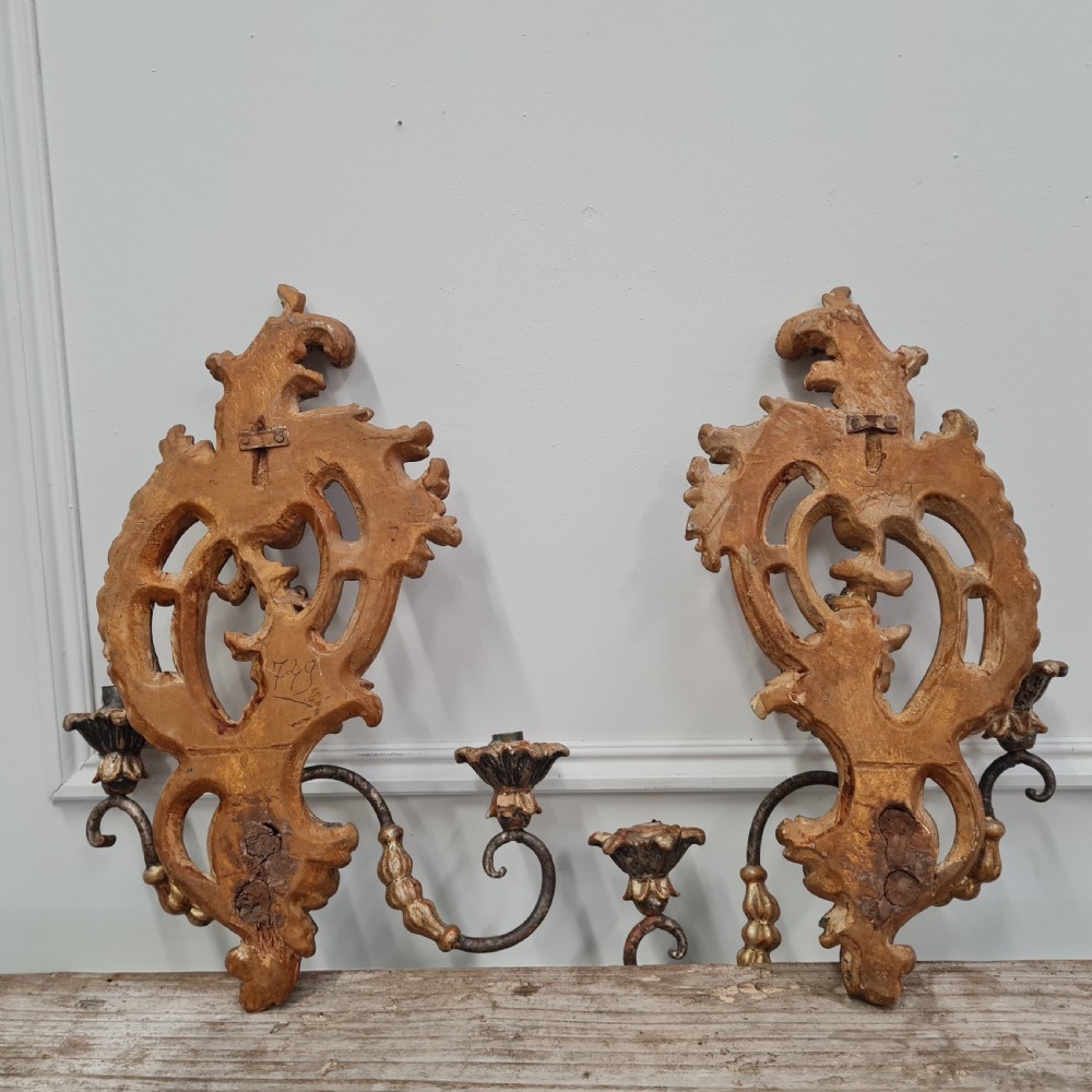 A pair of carved wood wall sconces featuring ornate scrollwork, aged silver leaf finish, and twin candle arms. View V