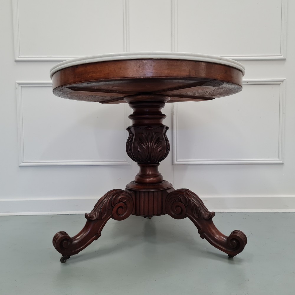 A 19th-century French gueridon table featuring a circular white marble top supported by a carved dark mahogany pedestal and scrolled tripod base. View V