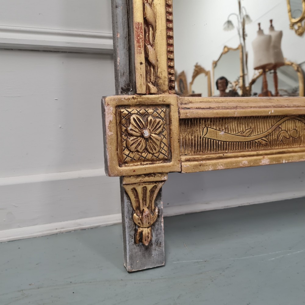 A large antique French giltwood marriage mirror circa 1900 featuring an elaborate carved crest with an urn and bird motifs above a rectangular beaded frame. View II