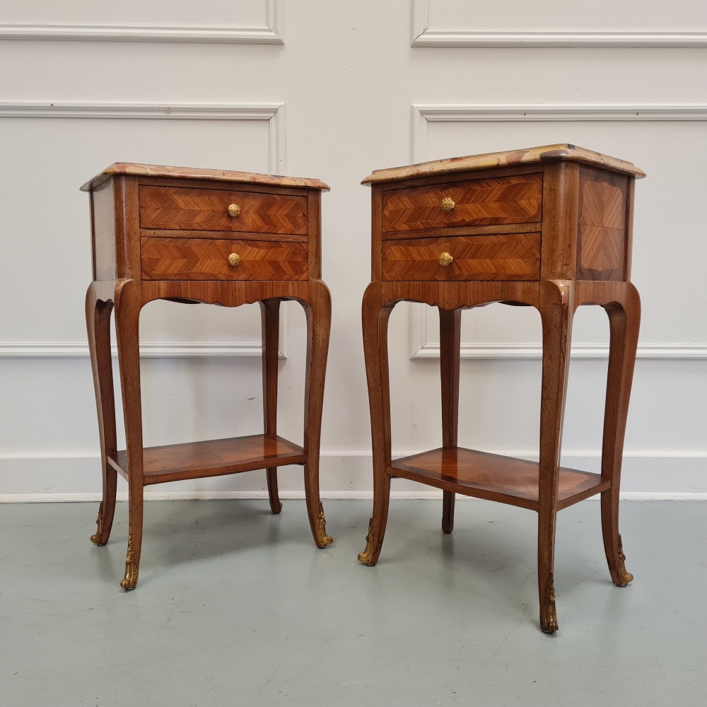 A pair of French 1930s serpentine bedside tables featuring marble tops, chevron veneer drawers, cabriole legs with brass mounts, and a lower shelf. View III