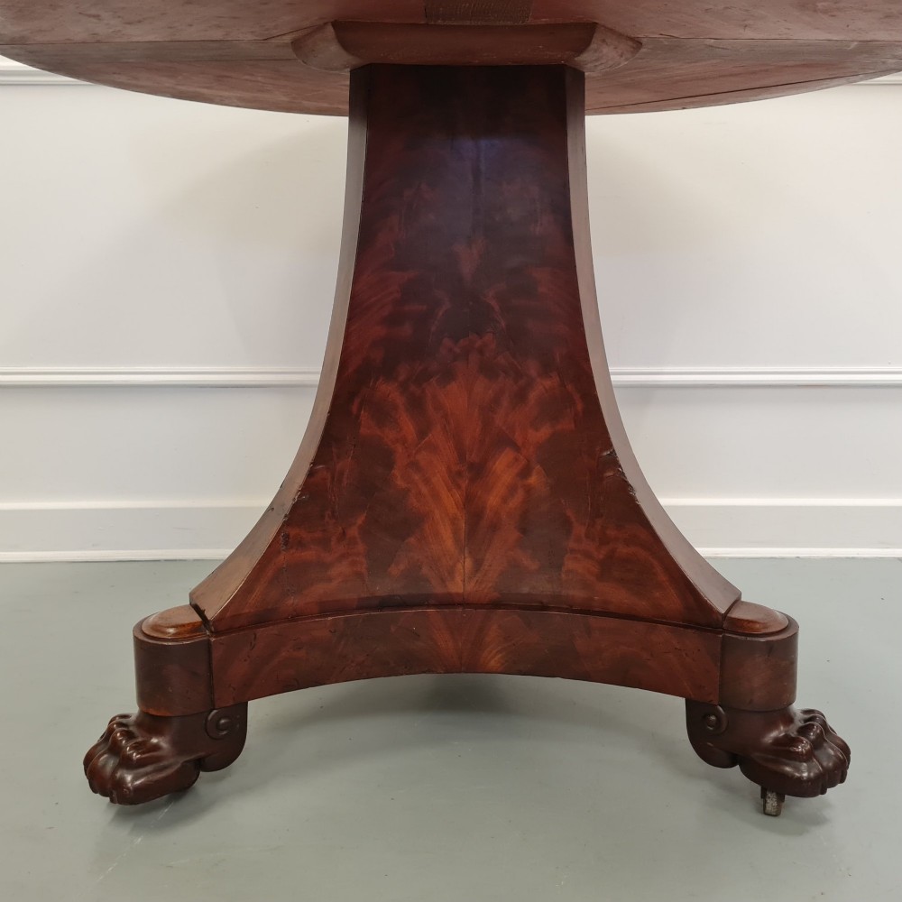 A 19th-century French gueridon featuring a circular dark grey marble top set upon a flame mahogany pedestal with a triform base and carved paw feet. View IV