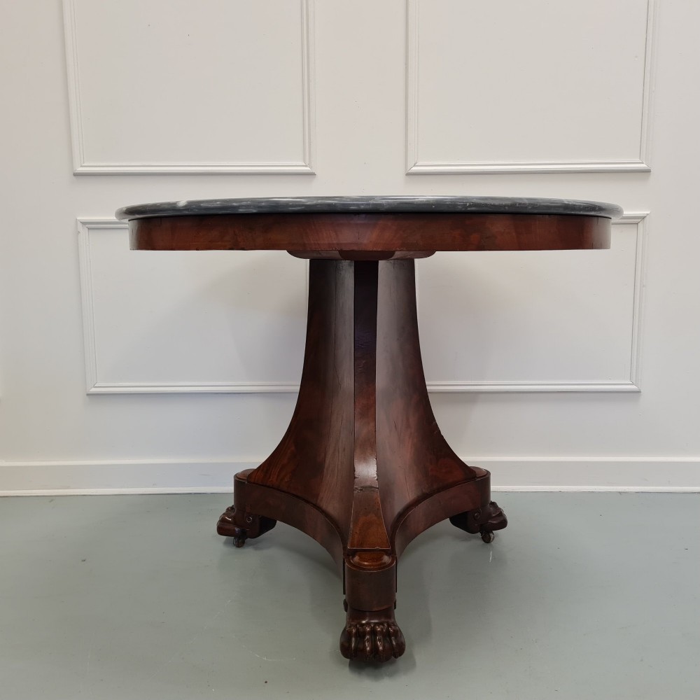 A 19th-century French gueridon featuring a circular dark grey marble top set upon a flame mahogany pedestal with a triform base and carved paw feet. View VI