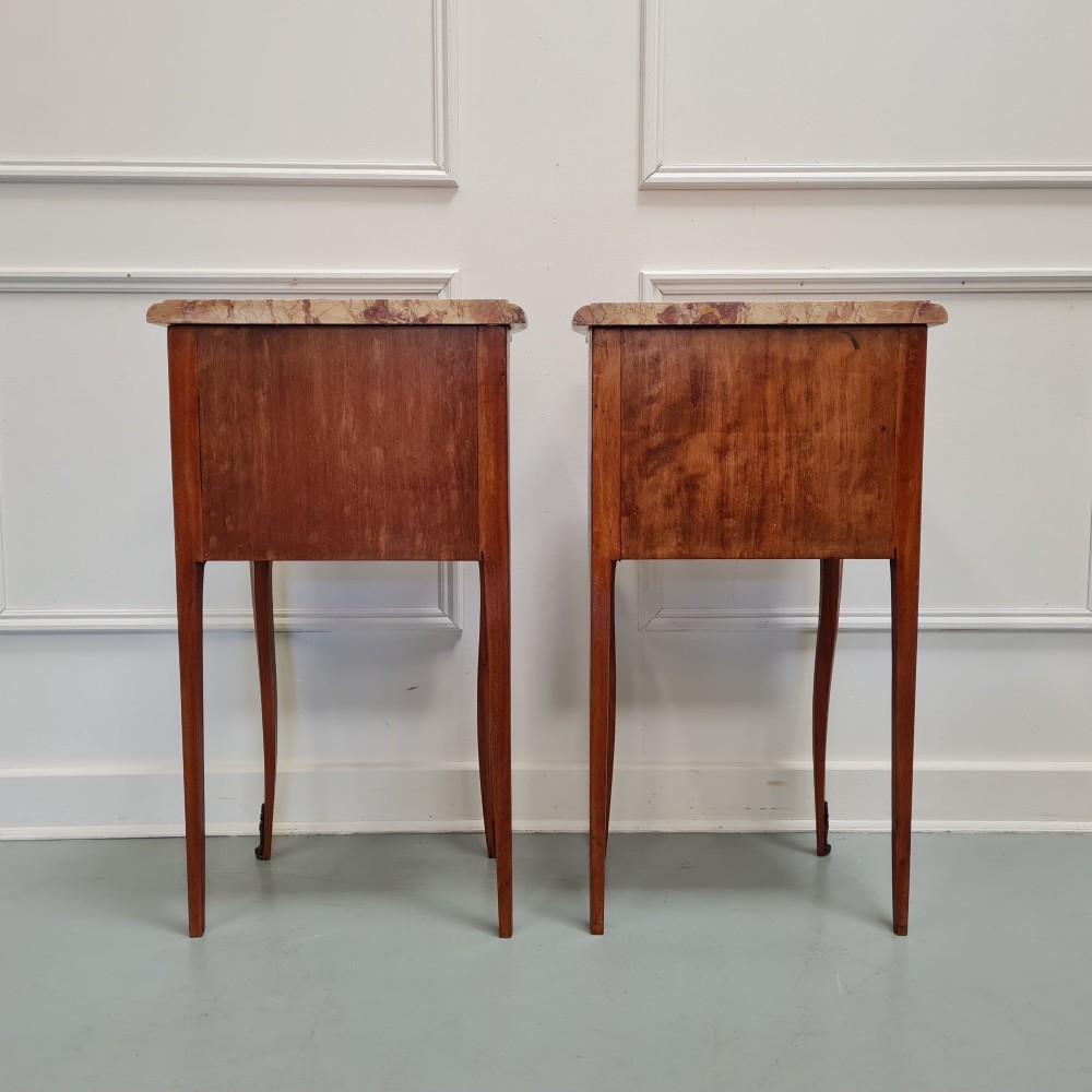 A pair of French 1930s bedside tables featuring variegated marble tops, walnut parquetry drawers, gilt brass mounts, and slender cabriole legs. View III