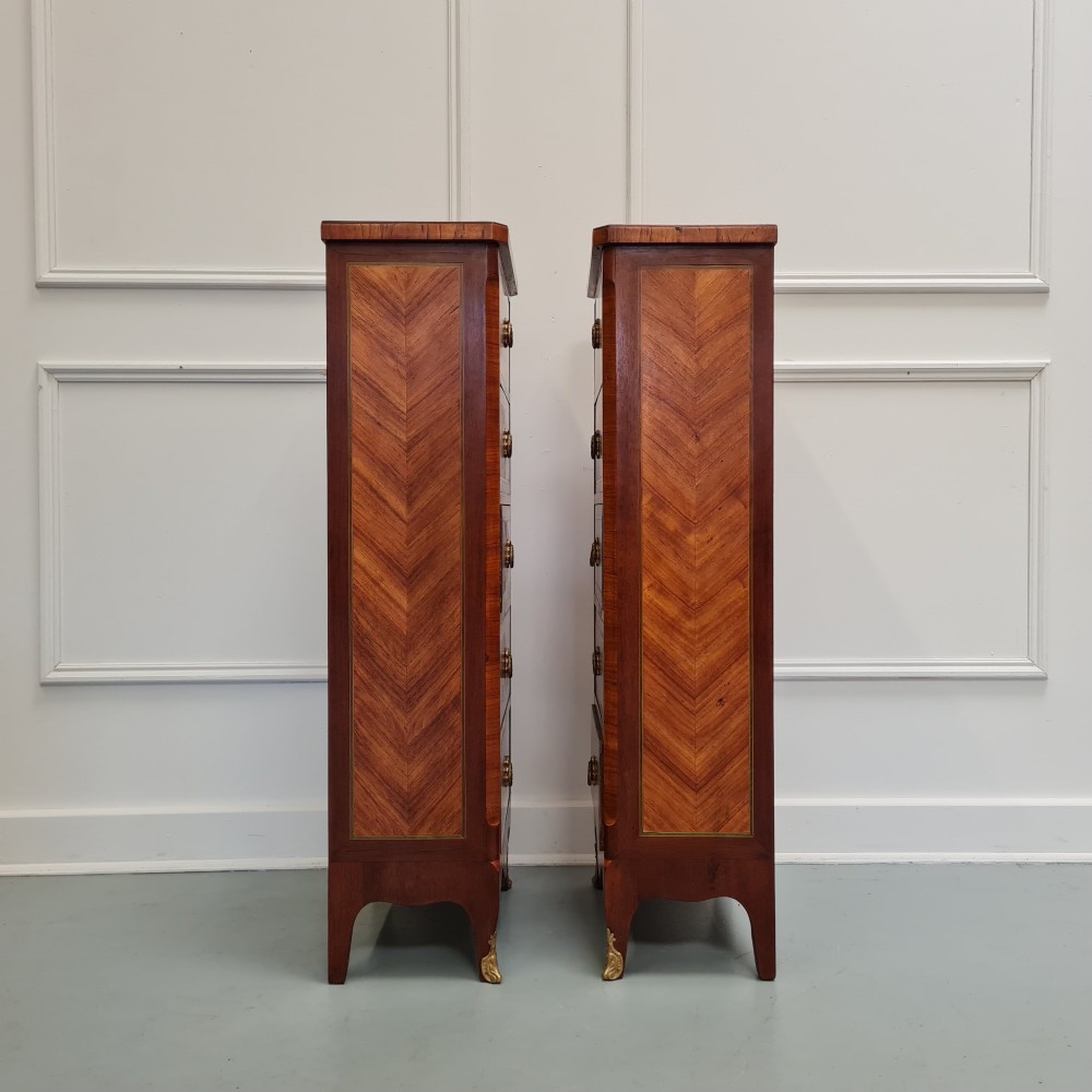 A pair of tall French-style wooden bedside cabinets with floral marquetry inlay, five drawers each, brass rosette handles, and curved cabriole legs with brass feet. View VI