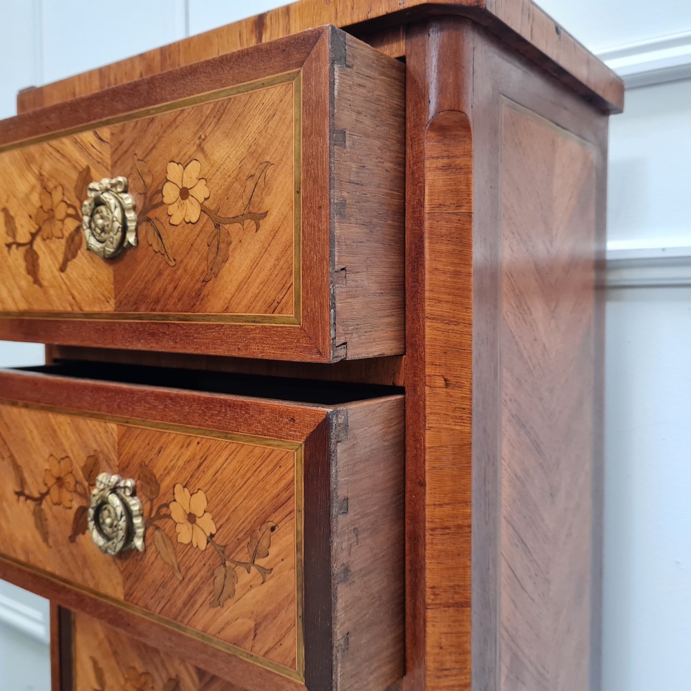 A pair of tall French-style wooden bedside cabinets with floral marquetry inlay, five drawers each, brass rosette handles, and curved cabriole legs with brass feet. View IX