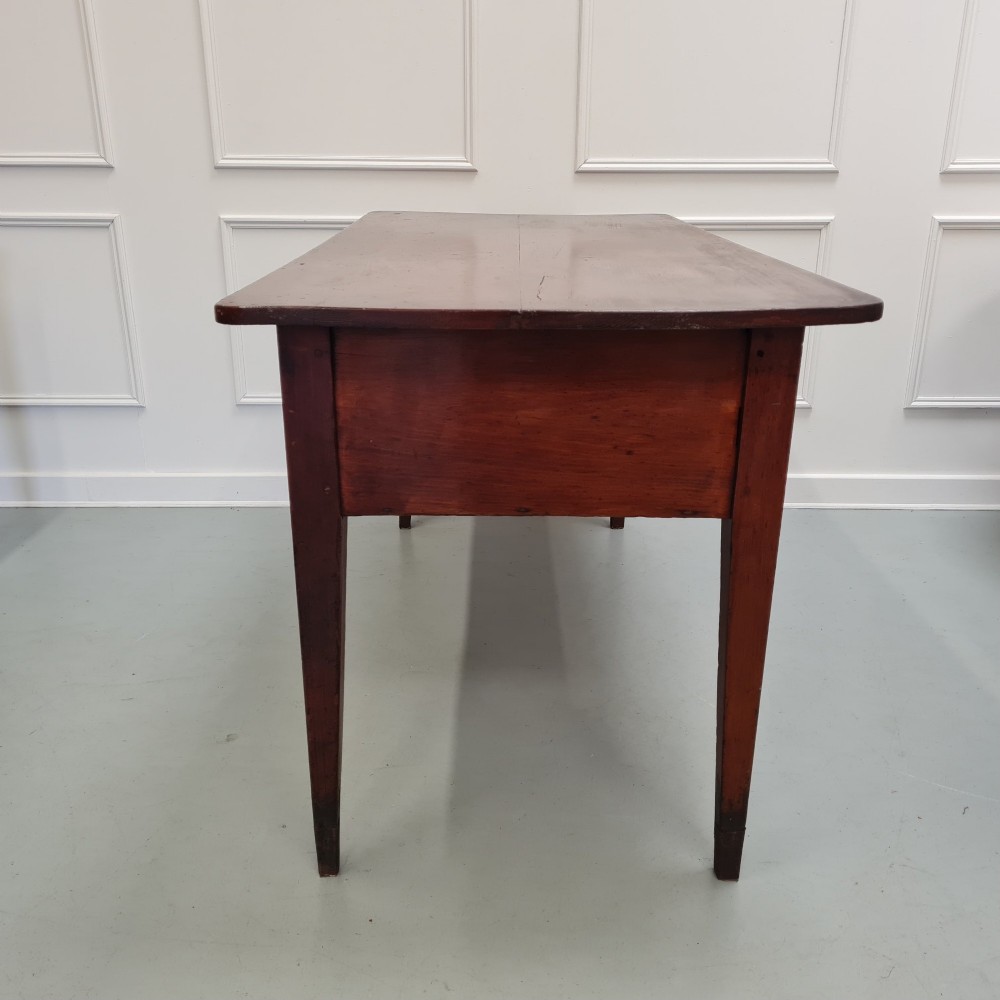 A mid-nineteenth-century warm brown wooden serving table featuring three drawers with turned knobs and four tapered square legs. View III
