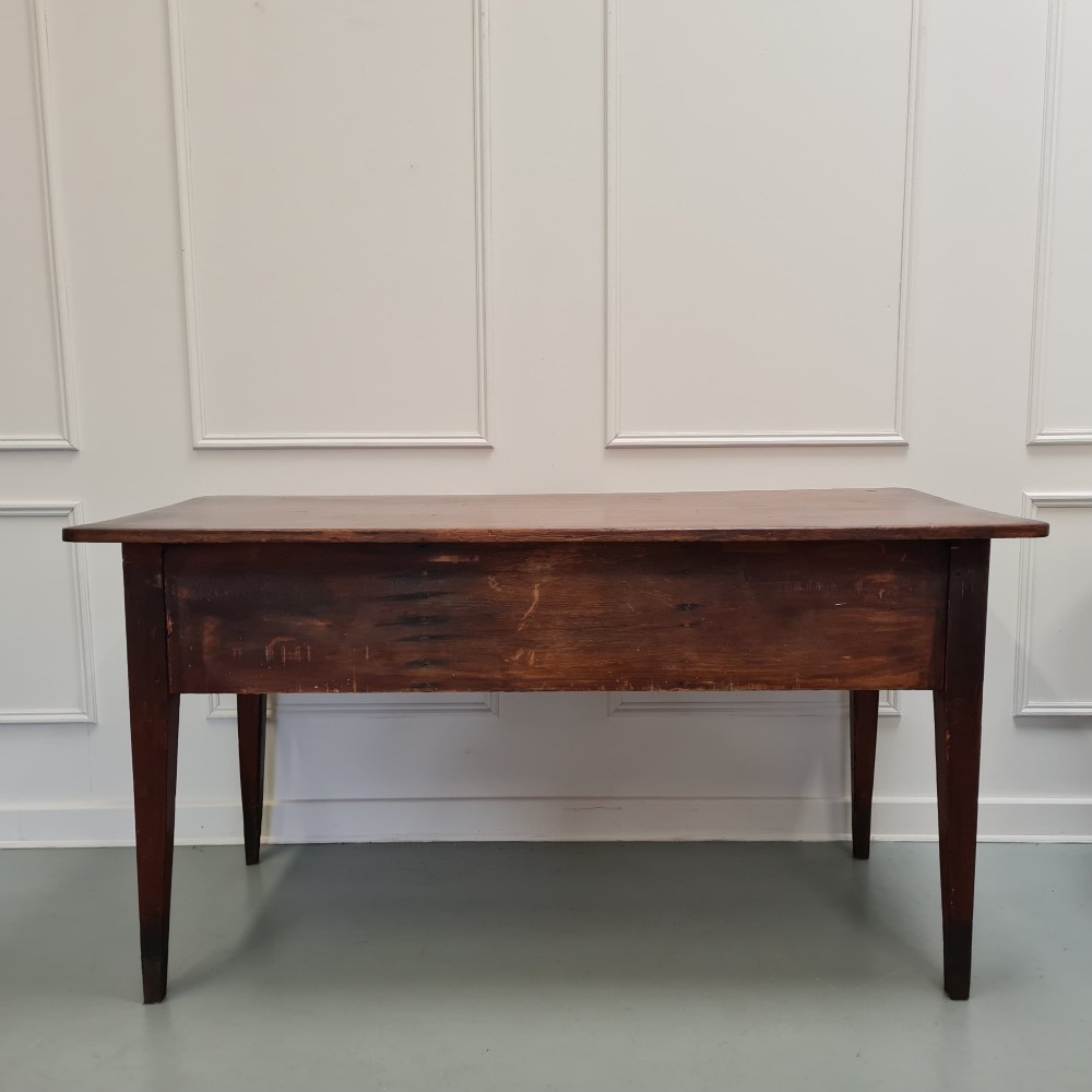 A mid-nineteenth-century warm brown wooden serving table featuring three drawers with turned knobs and four tapered square legs. View IV