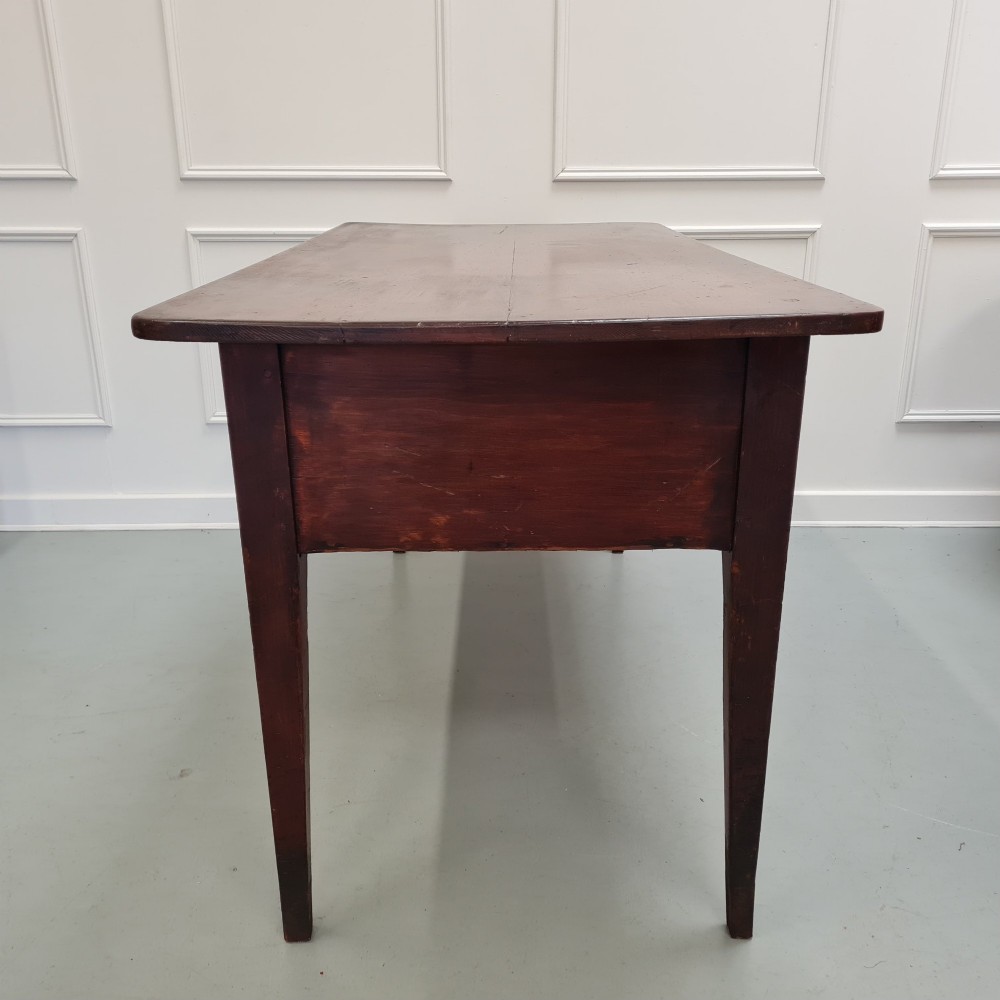 A mid-nineteenth-century warm brown wooden serving table featuring three drawers with turned knobs and four tapered square legs. View V