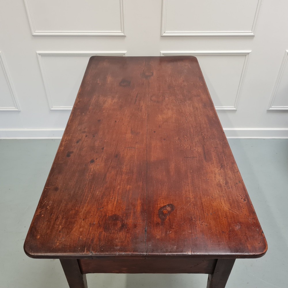 A mid-nineteenth-century warm brown wooden serving table featuring three drawers with turned knobs and four tapered square legs. View VI