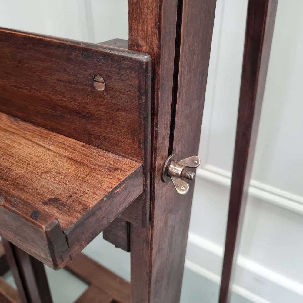 A dark brown French oak H-frame studio easel featuring an adjustable canvas shelf and metal side fixtures. View III