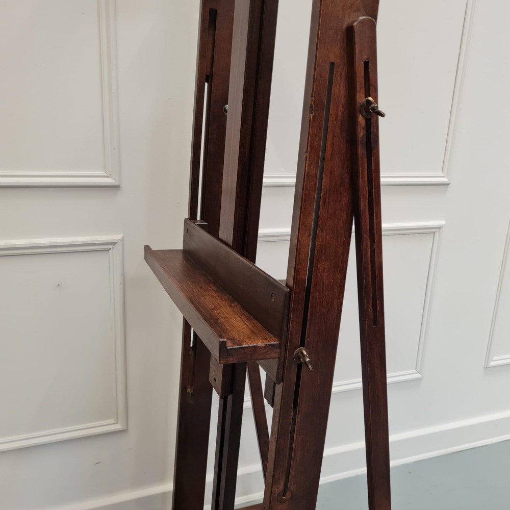 A dark brown French oak H-frame studio easel featuring an adjustable canvas shelf and metal side fixtures. View VI