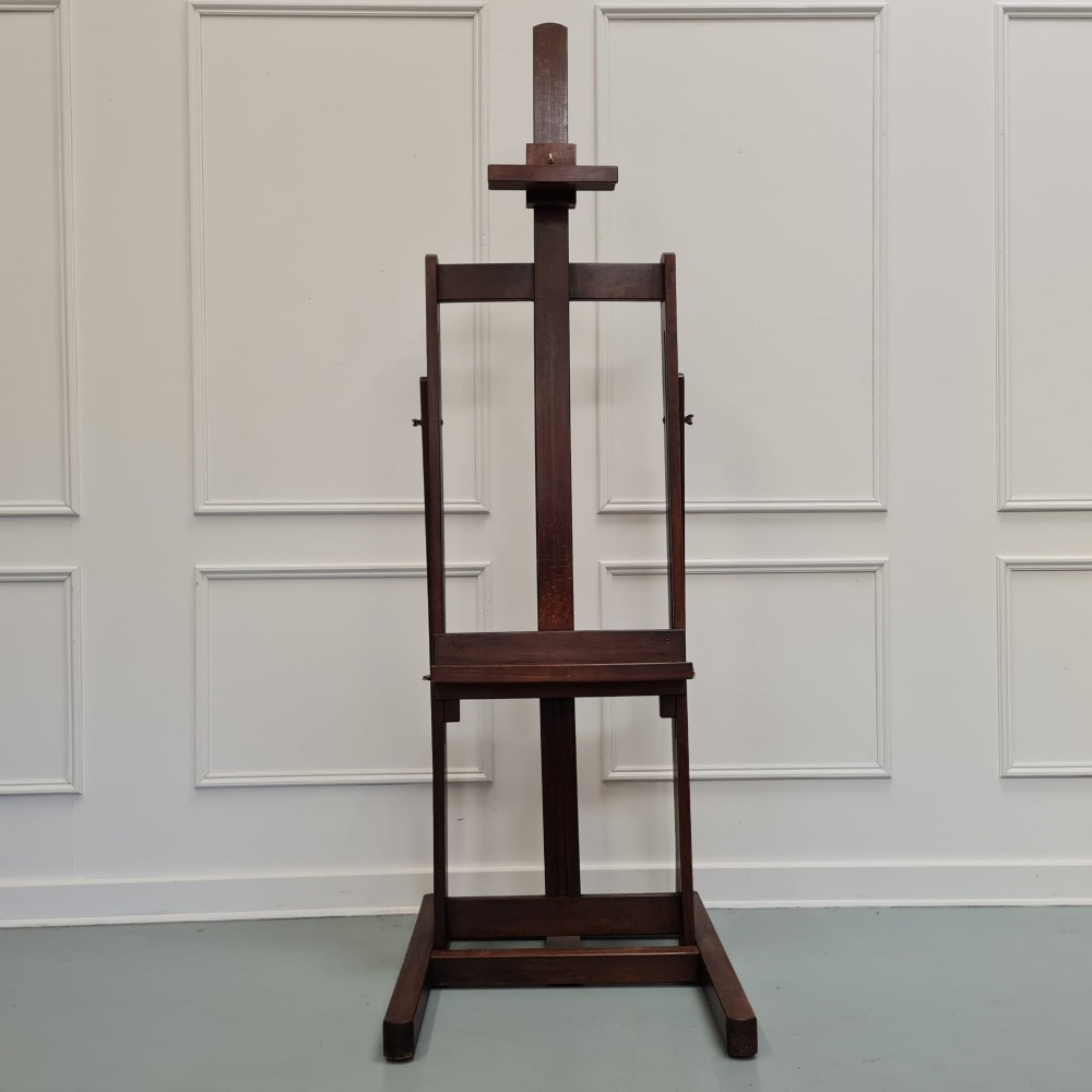 A dark brown French oak H-frame studio easel featuring an adjustable canvas shelf and metal side fixtures. View VIII