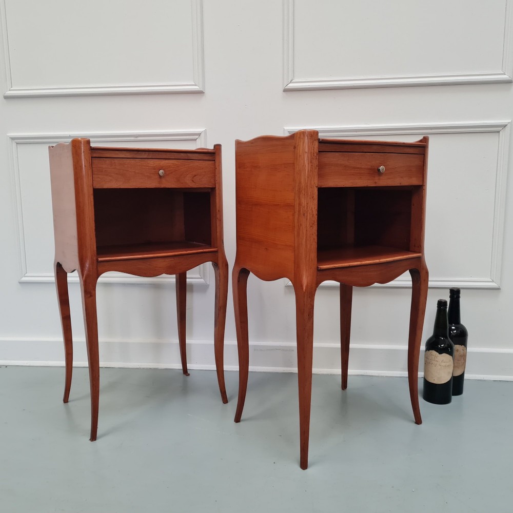 A pair of French cherry wood bedside tables featuring single drawers with small pull knobs, open lower shelves, and slender cabriole legs. View II