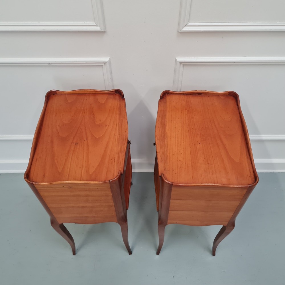 A pair of French cherry wood bedside tables featuring single drawers with small pull knobs, open lower shelves, and slender cabriole legs. View V