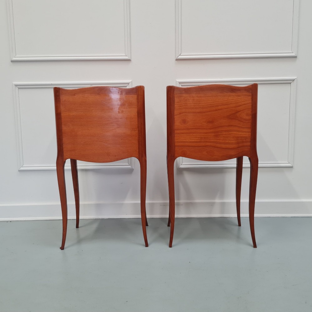 A pair of French cherry wood bedside tables featuring single drawers with small pull knobs, open lower shelves, and slender cabriole legs. View VI