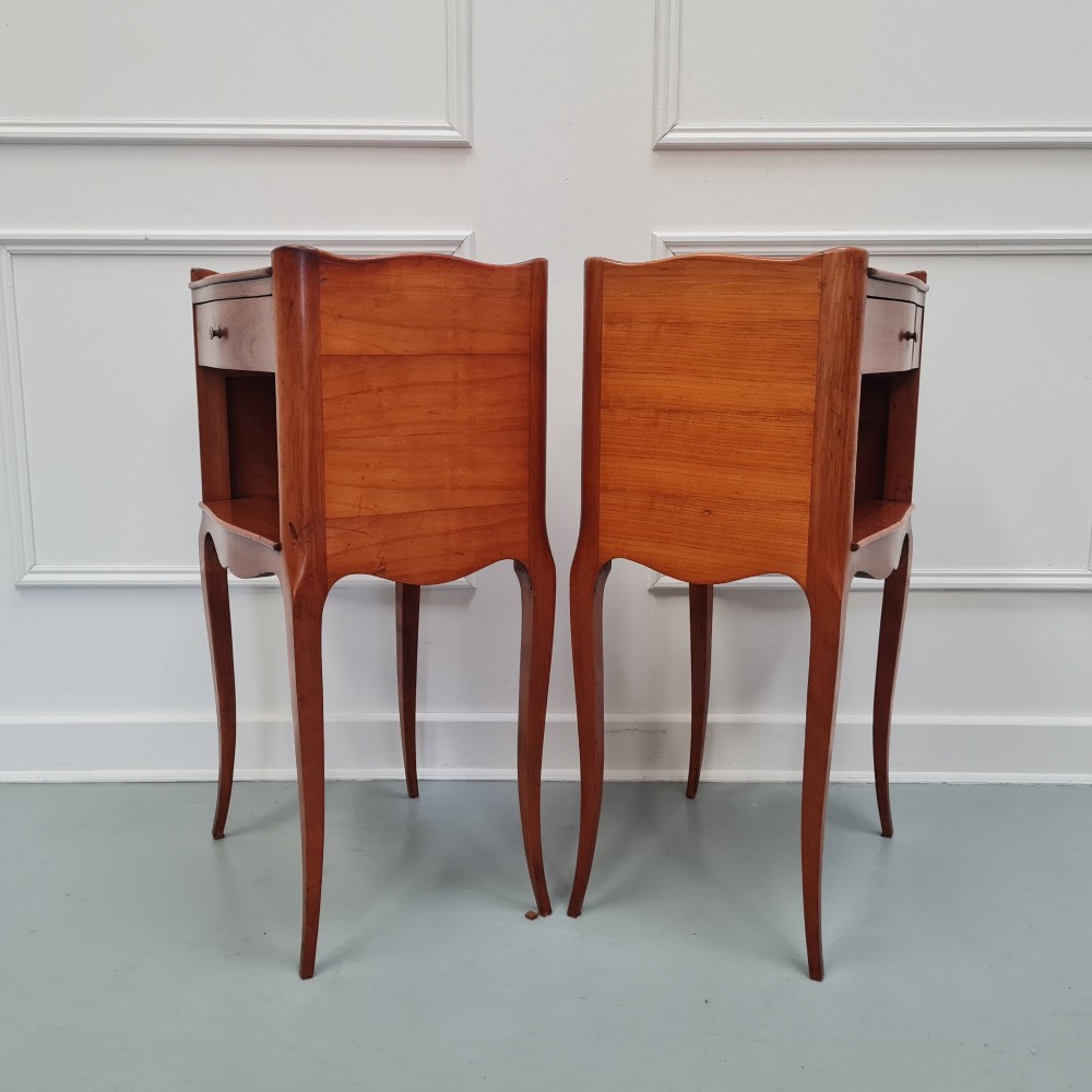 A pair of French cherry wood bedside tables featuring single drawers with small pull knobs, open lower shelves, and slender cabriole legs. View VII