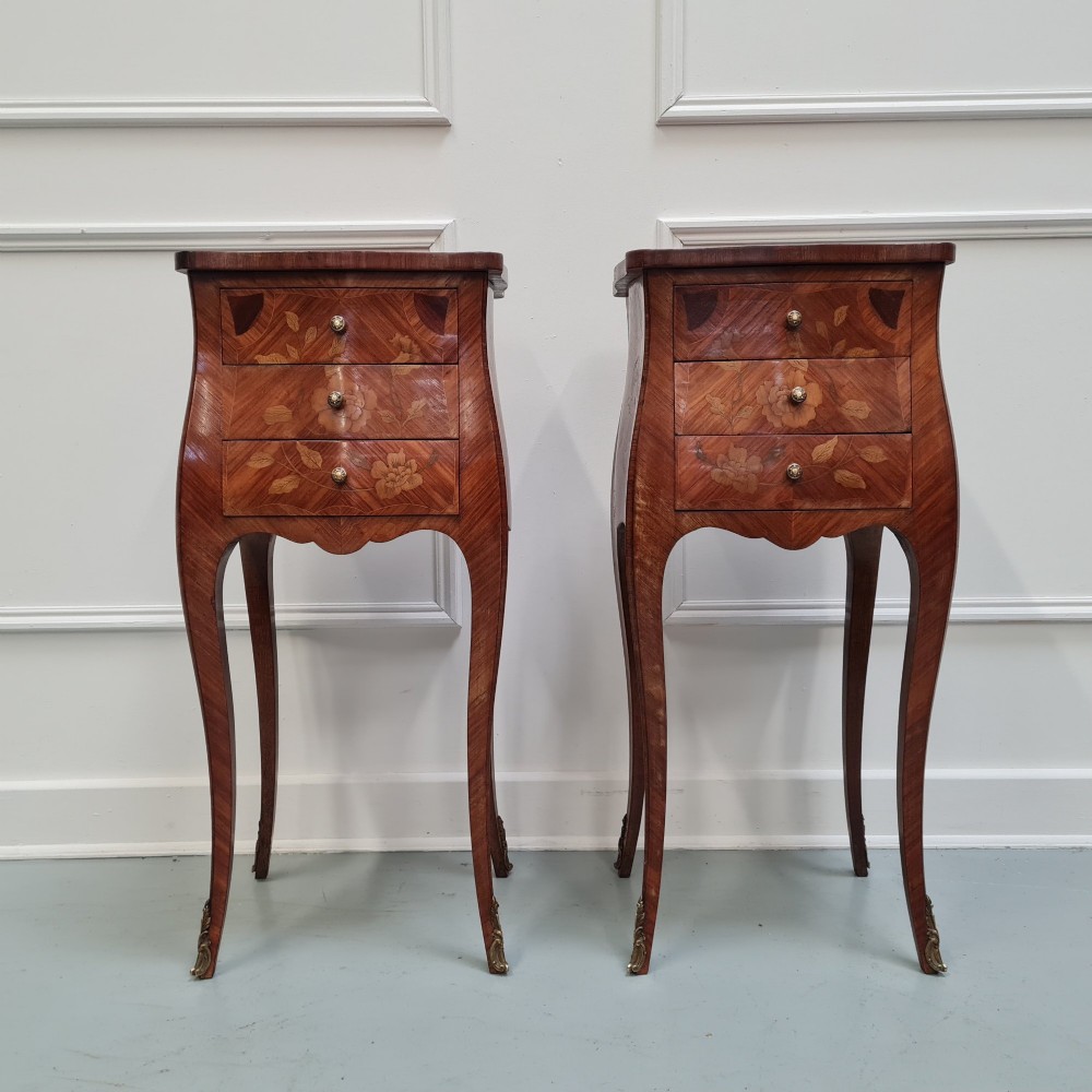 Pair of slender French Kingwood bedside tables with floral marquetry drawers and cabriole legs featuring brass sabots.
