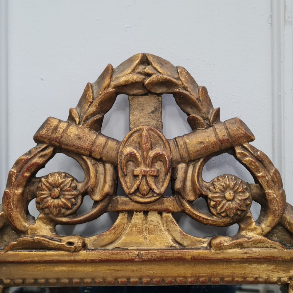 A small 18th-century style French giltwood mirror featuring carved cresting with floral rosettes and a fleur-de-lis motif. View III