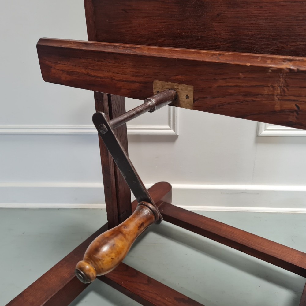 An antique dark oak studio winder easel featuring a mechanical hand crank handle and a floor base equipped with castors. View II
