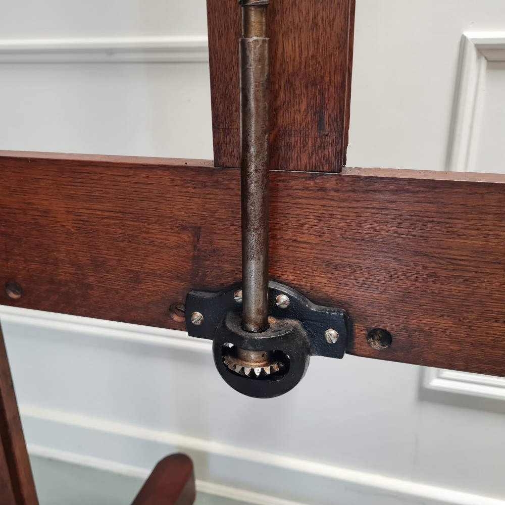 An antique dark oak studio winder easel featuring a mechanical hand crank handle and a floor base equipped with castors. View VII