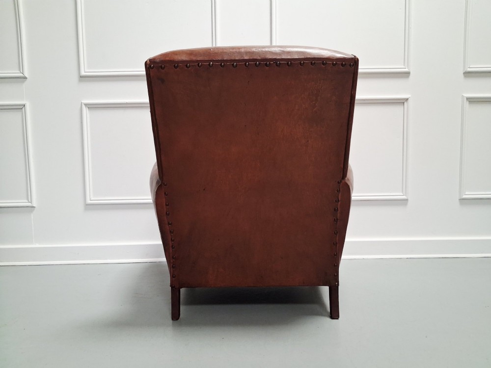 A 1930s French leather club chair upholstered in warm cognac brown patinated leather with rounded armrests and short square feet. View IV