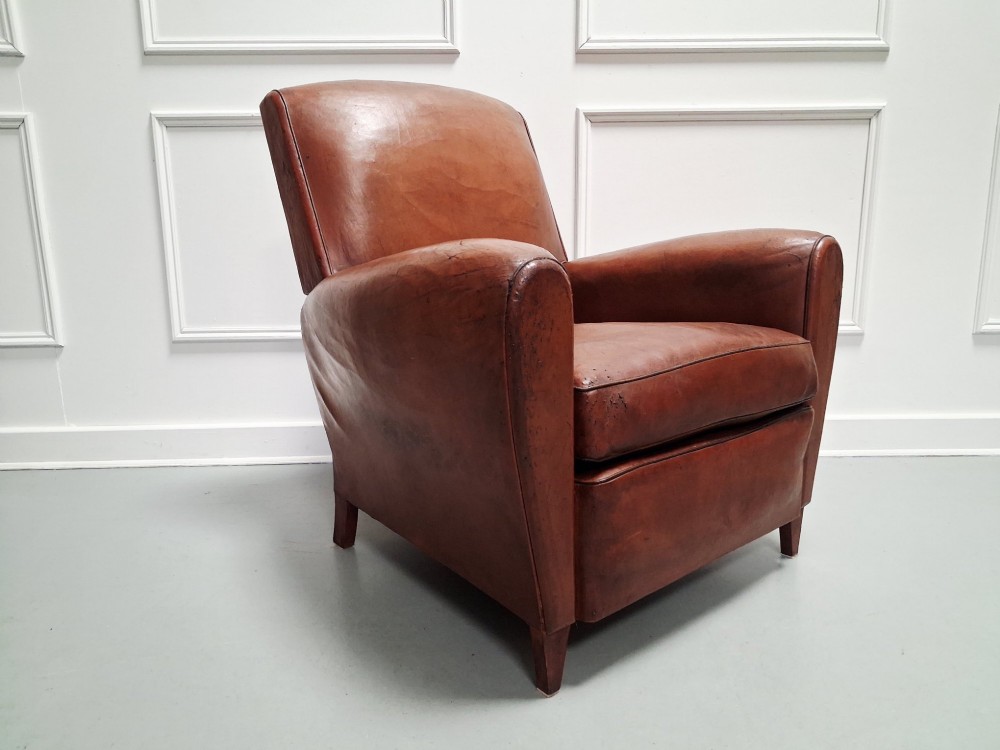 A 1930s French leather club chair upholstered in warm cognac brown patinated leather with rounded armrests and short square feet. View VI