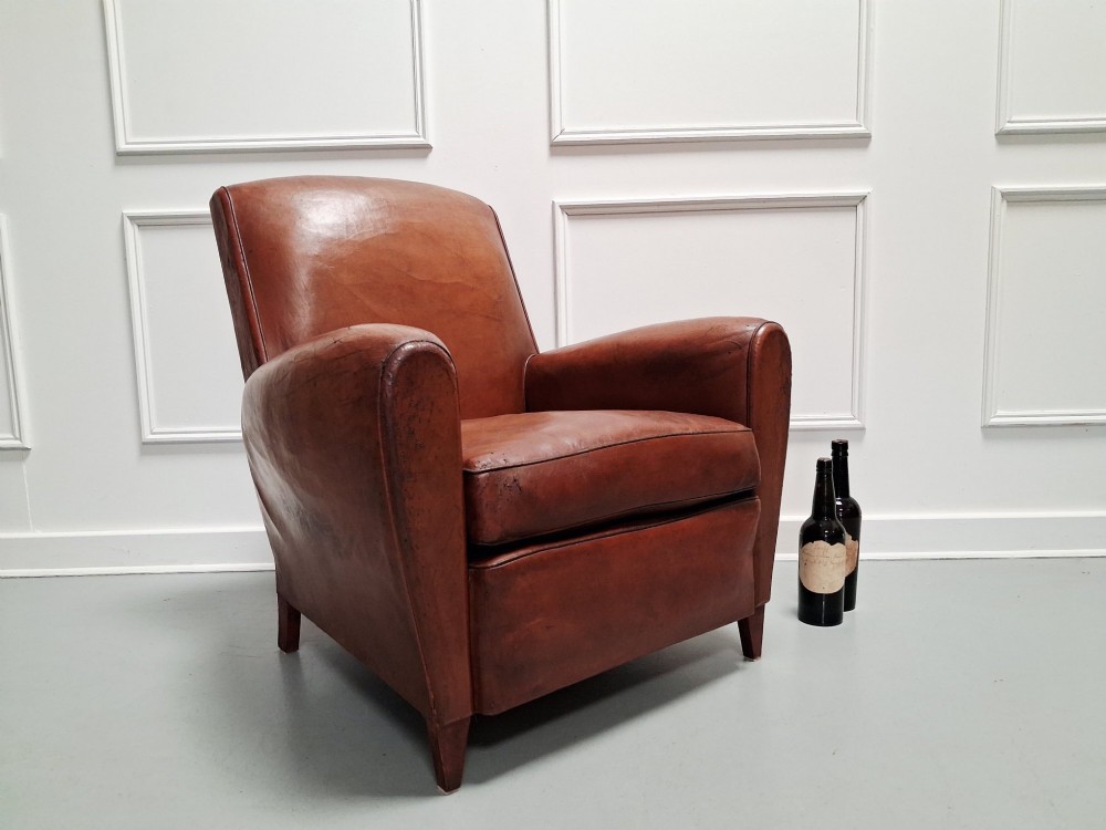 A 1930s French leather club chair upholstered in warm cognac brown patinated leather with rounded armrests and short square feet. View VII
