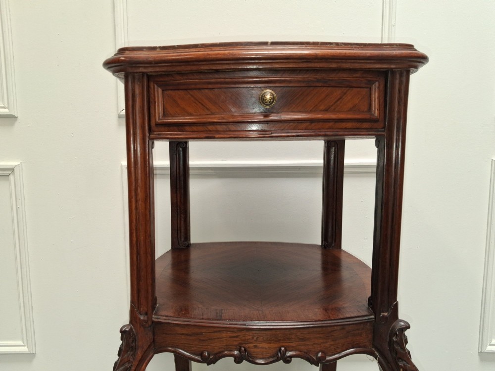 A matching pair of tall dark wood end tables featuring top drawers, lower open shelves, carved cabriole legs, and brass castors. View VII