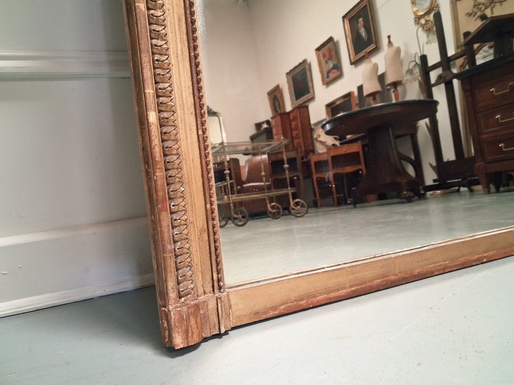 Large 19th-century French giltwood mirror with a carved crest pediment and beaded inner frame. View III