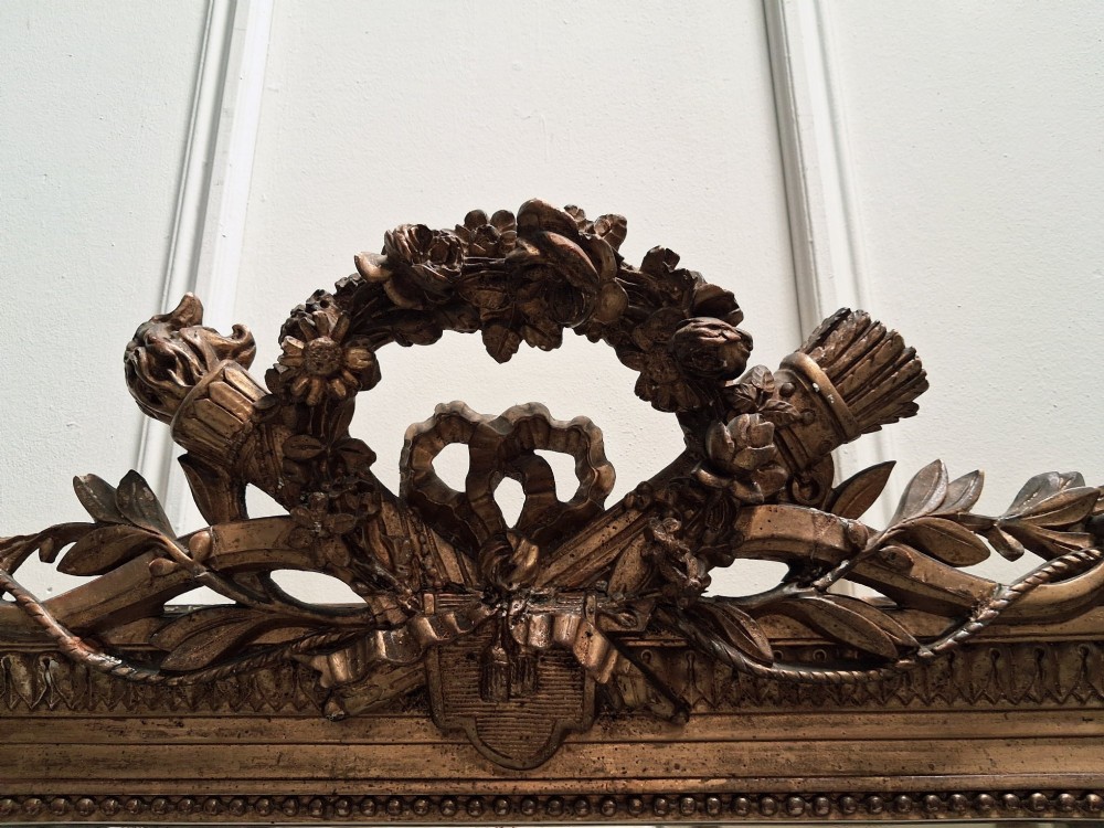 Large 19th-century French giltwood mirror with a carved crest pediment and beaded inner frame. View IV