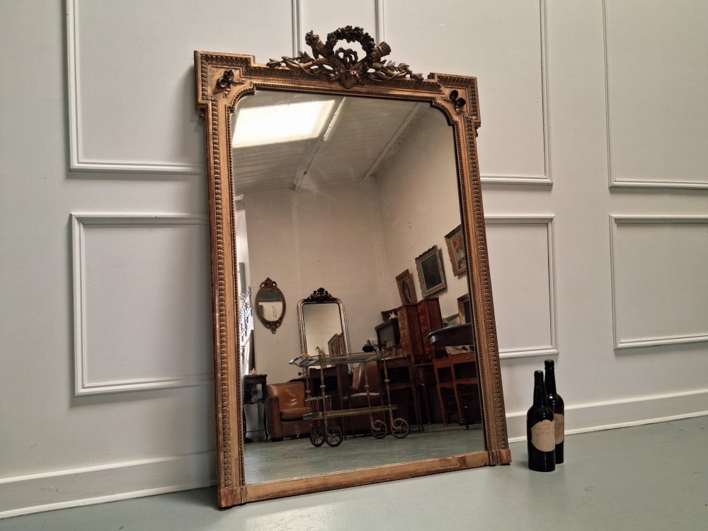 Large 19th-century French giltwood mirror with a carved crest pediment and beaded inner frame. View VI