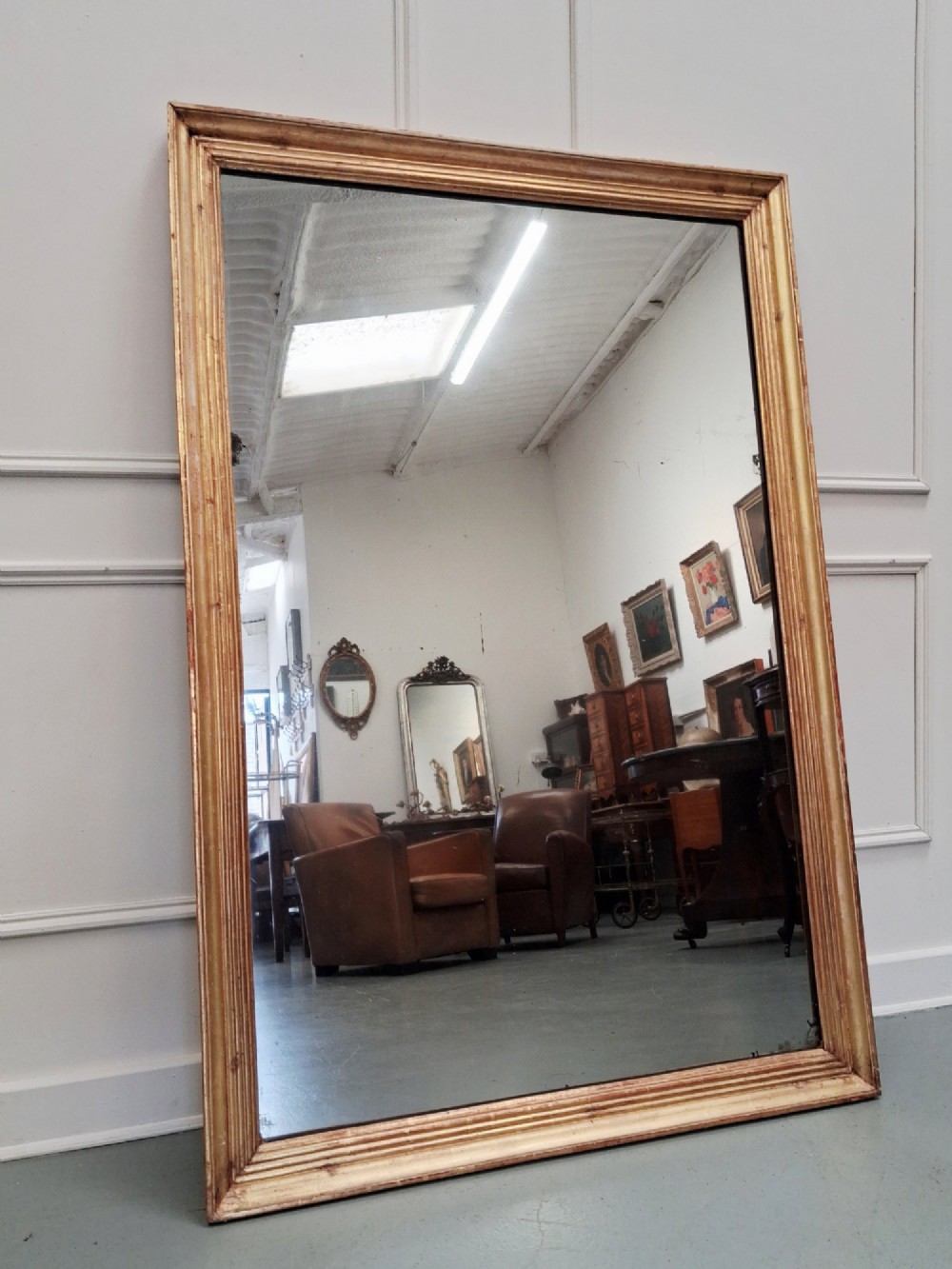 A large rectangular antique mirror featuring a ribbed gilded timber frame with natural age patination. View IV