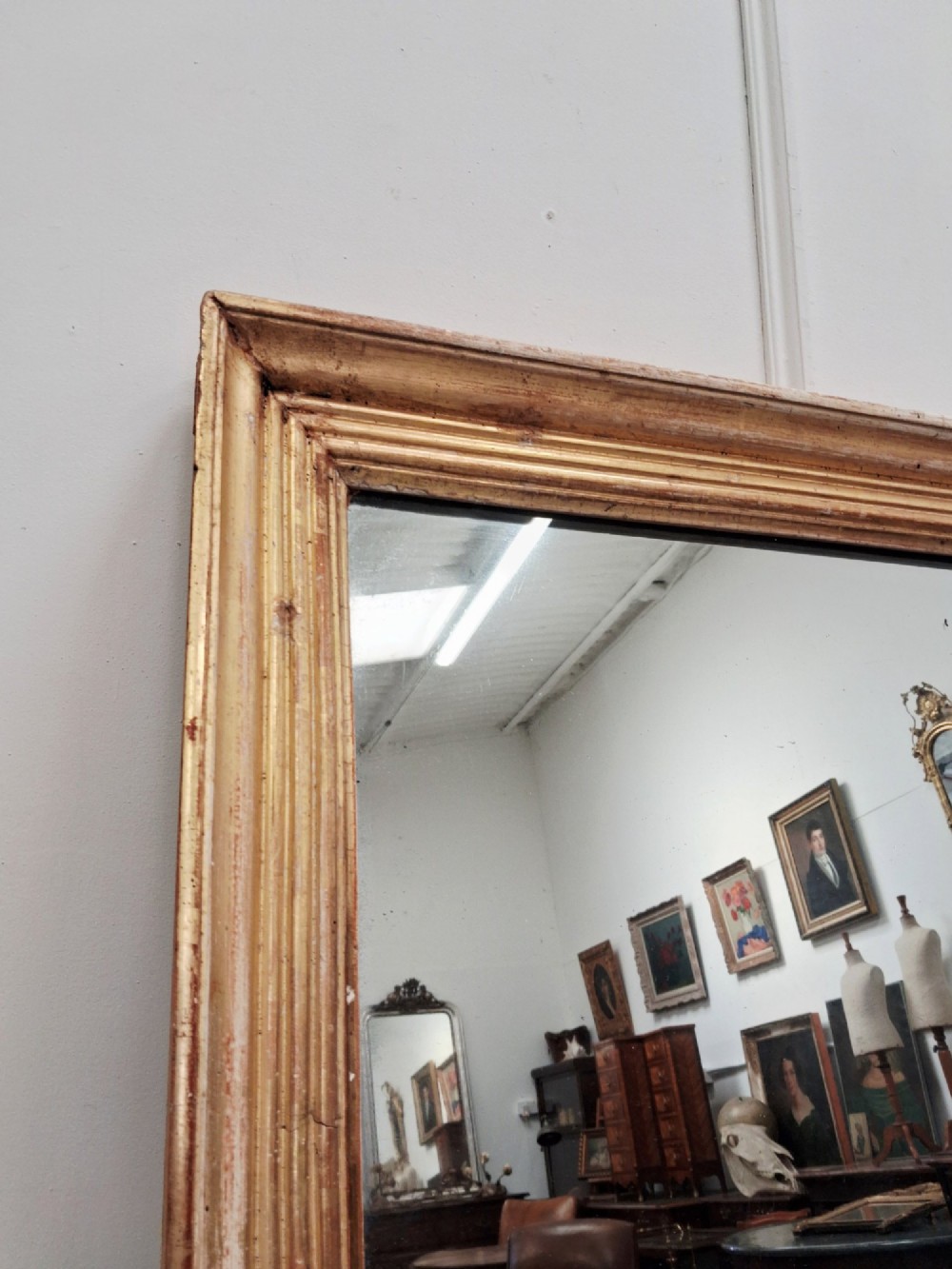 A large rectangular antique mirror featuring a ribbed gilded timber frame with natural age patination. View VII