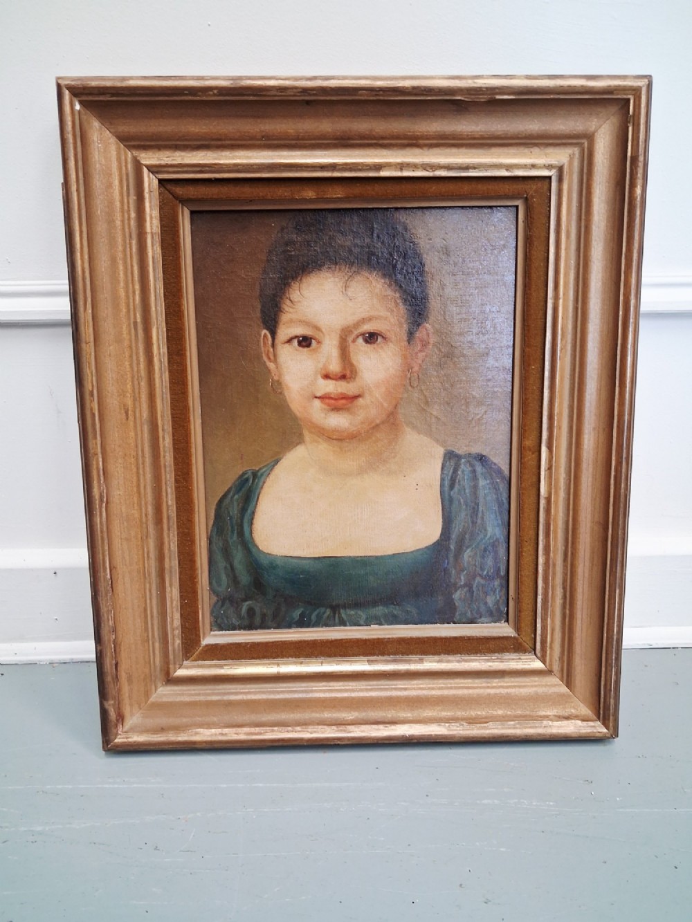 A pair of 19th-century oil portrait paintings depicting a young girl and boy set inside wide moulded giltwood frames. View III