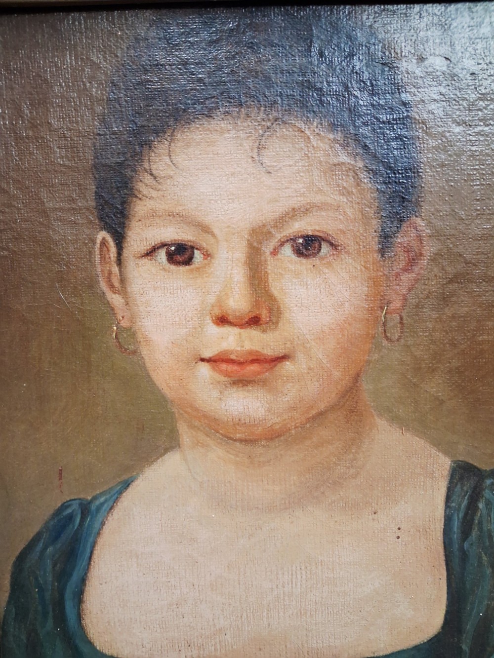 A pair of 19th-century oil portrait paintings depicting a young girl and boy set inside wide moulded giltwood frames. View V