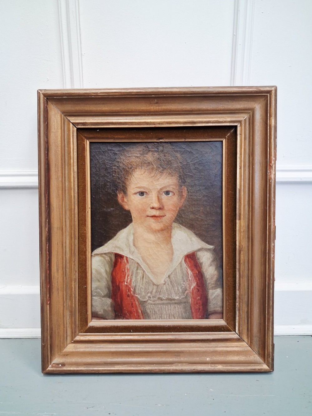 A pair of 19th-century oil portrait paintings depicting a young girl and boy set inside wide moulded giltwood frames. View VIII